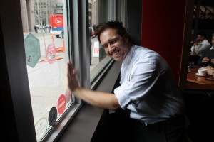 Chef Darren Maclean of Downtown Food won silver, seen here applying his new Gold Medal Plates Emblem of Excellence to the restaurant window.